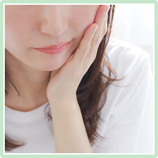 頬を抑える女性